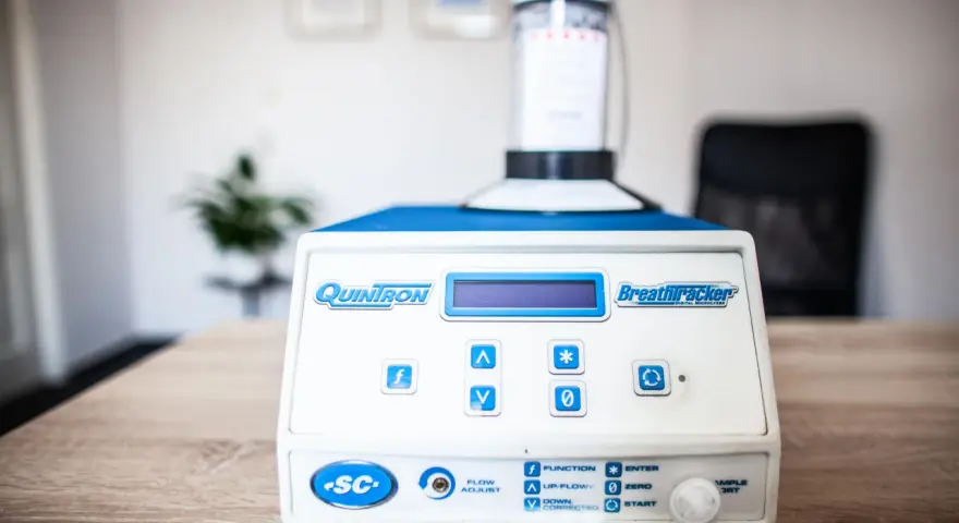 Urządzenie QuinTron BreathTracker do analizy oddechu na stole.