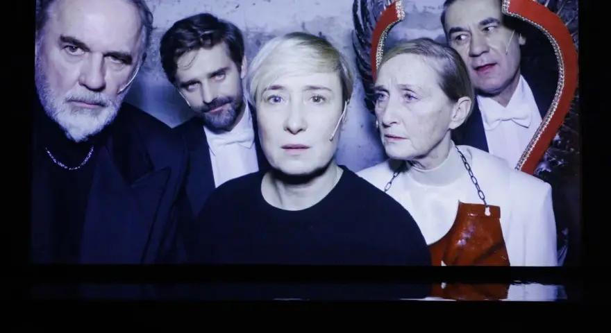 Kazimierz, reżyser i aktor teatralny, w otoczeniu aktorów na scenie.