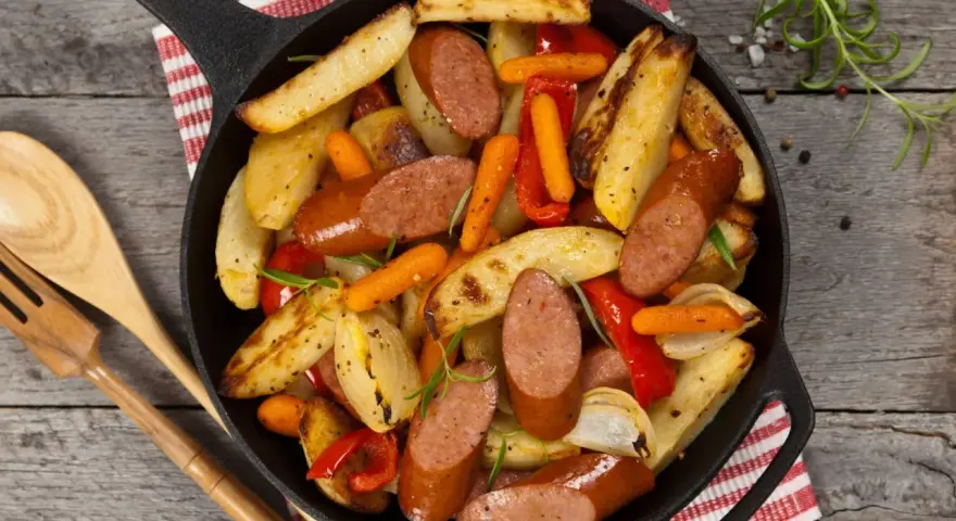 Stare przepisy na obiad: kiełbasa z ziemniakami, marchewką i papryką zapiekane w żeliwnej patelni.