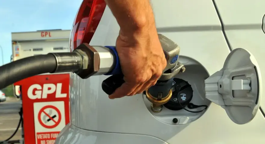 Rifornimento GPL in autostrada. Mano che inserisce la pistola nel serbatoio dell'auto.