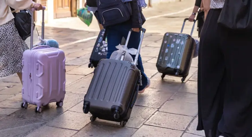 Ludzie z walizkami na kółkach, zastanawiający się, ile dopłata za bagaż Ryanair.