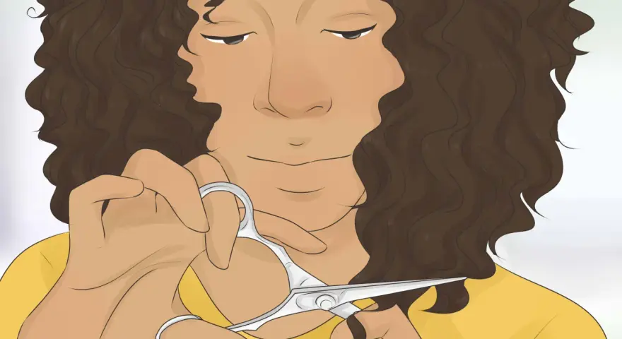 Persona con cabello castaño rizado a capas se corta el pelo con tijeras.
