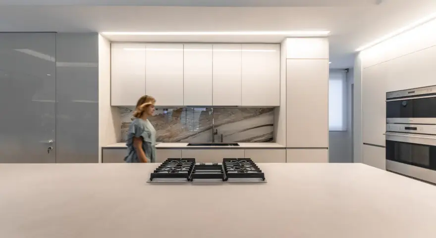 Cocina moderna con iluminación LED integrada en los gabinetes y el techo, ideal para saber como iluminar una cocina.