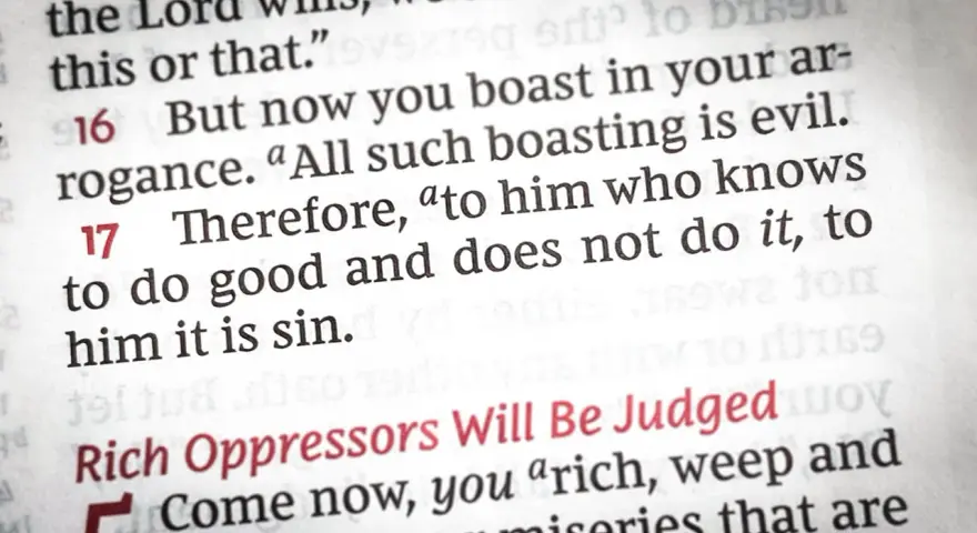 Close-up of a Bible page, showing text about the sin of omission: "to him who knows to do good and does not do it, to him it is sin.