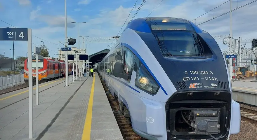 Nowoczesny pociąg PKP Intercity ED161 na peronie, obok innego pociągu.