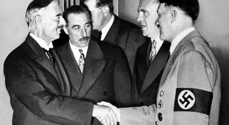 Neville Chamberlain y Adolf Hitler se dan la mano en la conferencia de Múnich, un momento clave de la historia.