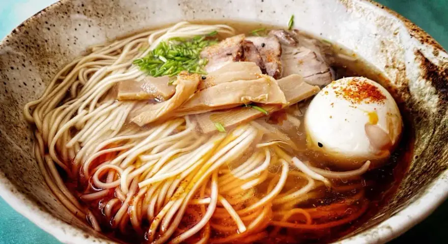 Miseczka aromatycznego ramenu z makaronem, jajkiem, mięsem i bambusem. Idealny przepis, jak zrobić ramen.