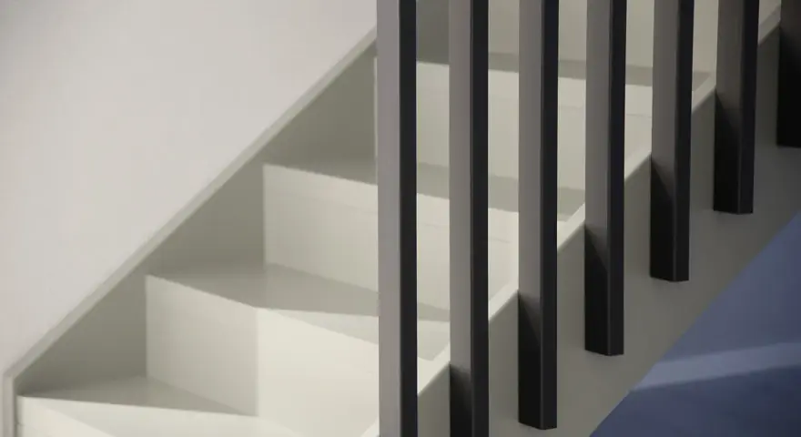 Renovera trappan med inspiration från denna moderna, stilrena design. Vita steg möter mörka räcken för en elegant look.