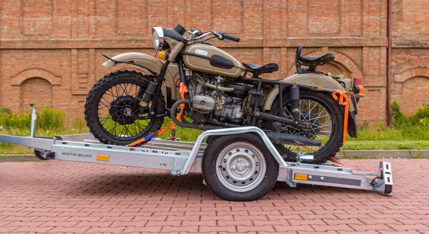 Jak przewieźć motocykl? Na przyczepie MOTO-QUAD, zabezpieczony pasami. Klasyczny motocykl z wózkiem bocznym czeka na transport.