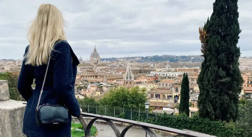 Blondynka podziwia panoramę Rzymu w listopadzie. Pochmurna pogoda nie przeszkadza w zwiedzaniu.