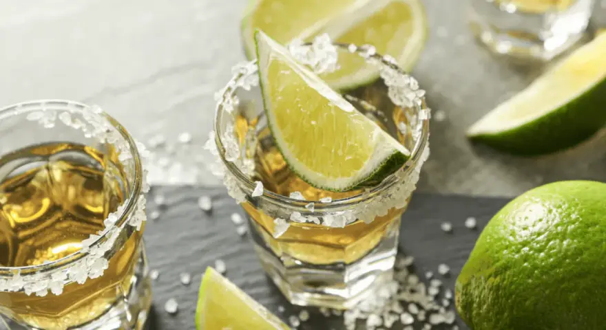 Jak pić tequilę gold? Kieliszki z solą i limonką, gotowe do degustacji.
