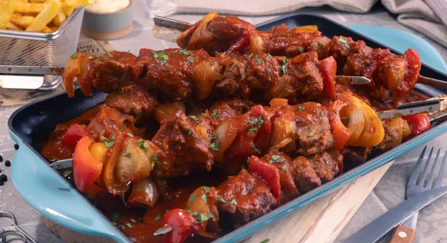 Herzhaftes Schaschlik im original Rezept-Stil, mit saftigem Fleisch, Paprika und Zwiebeln in würziger Sauce. Dazu knusprige Pommes.