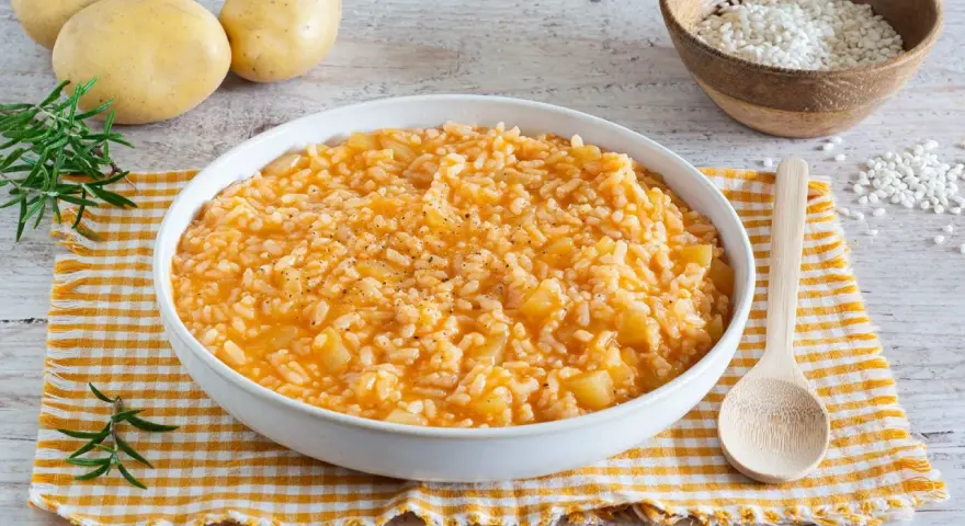 Un cremoso risotto con patate, arricchito da pepe nero e rosmarino fresco. Ingredienti semplici per un piatto confortante.