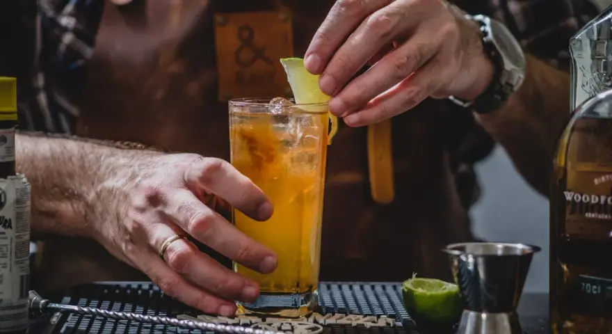 Barman kończy przygotowywać drinka na tequili, dodając plasterek limonki.
