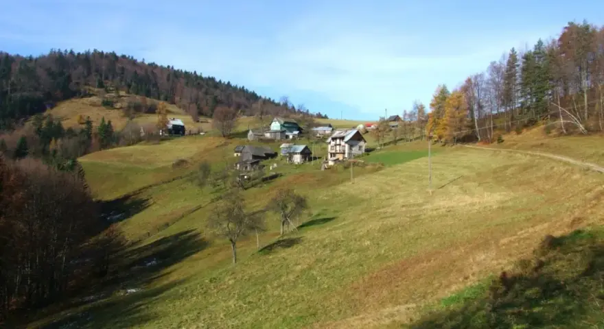 Jesienne krajobrazy Krynica Zdrój szczyty. Domy na zboczach, lasy i łąki.