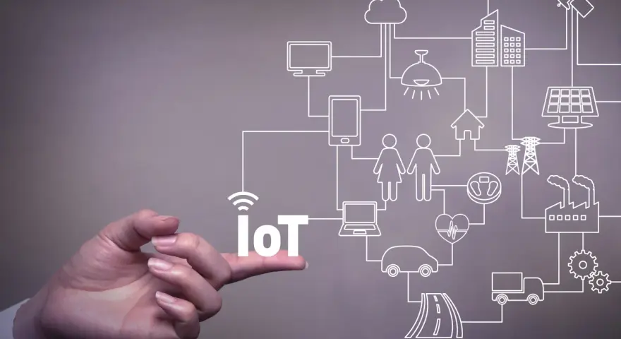 A hand points to the word "IoT," illustrating the vast network of connected devices and systems that offer significant **iot benefits for business**, from smart homes to factories.