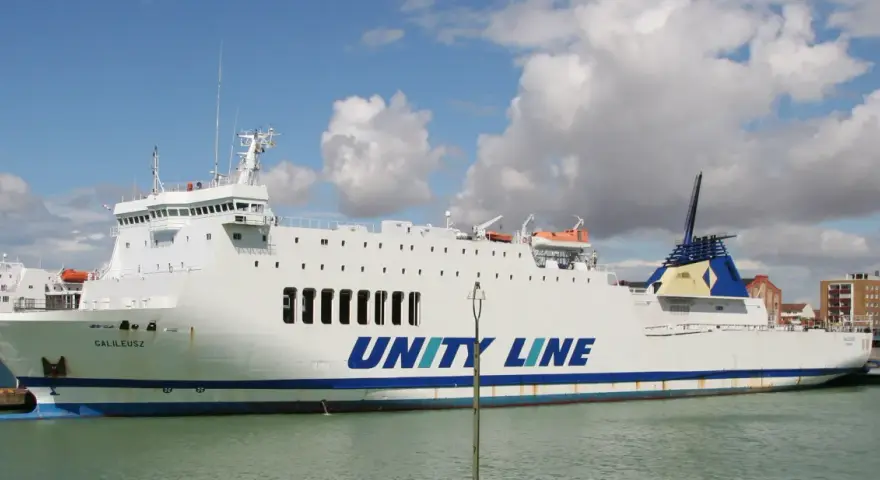 Biały prom Galileusz z napisem "UNITY LINE" cumuje w porcie.