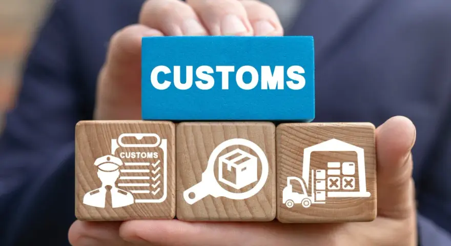 Klocki z symbolami celnymi i napisem "CUSTOMS" ilustrują proces odprawy towarów importowanych.