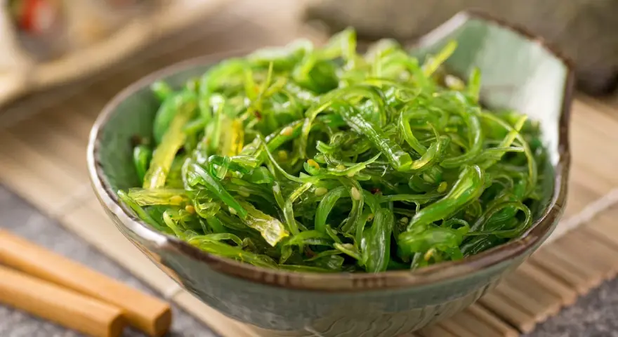 Miseczka zielonej sałatki z wodorostów wakame, idealna do sushi. Prosty wakame przepis na zdrową przekąskę.