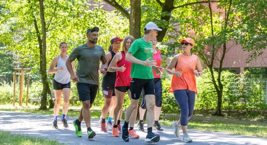 Eine Gruppe von Läufern genießt eine gemeinsame Trainingseinheit in Berlin. Die Laufgruppen Berlin sind aktiv und motiviert.