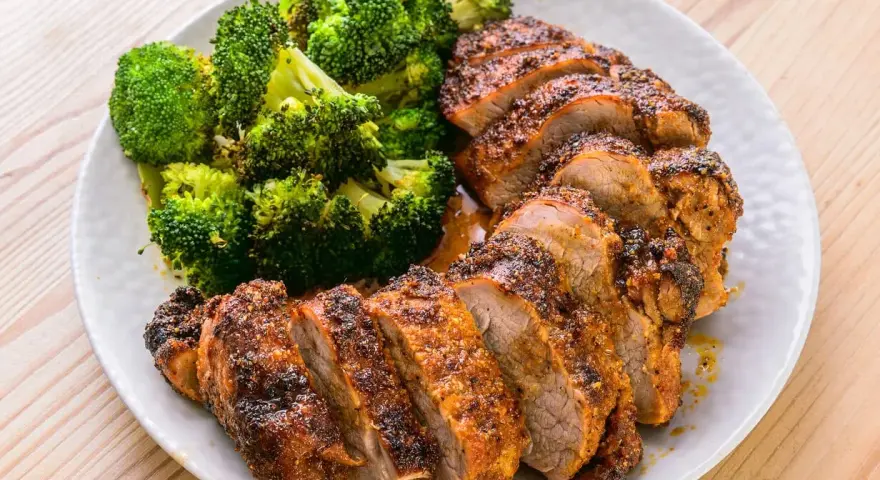 Filet mignon air fryer, tranché et servi avec du brocoli rôti. Un repas sain et savoureux.