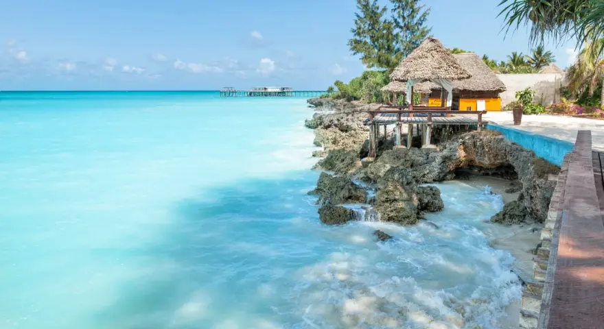Turkusowe morze i tropikalna zabudowa na skale. Idealne miejsce na relaks, a zanzibar ceny mogą być zaskakująco przystępne.