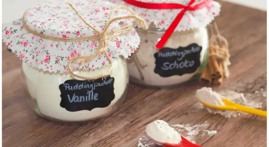 Zwei Gläser mit selbstgemachtem Vanillepuddingpulver und Schokopulver, liebevoll verziert. Perfekt zum vanillepuddingpulver selber machen.