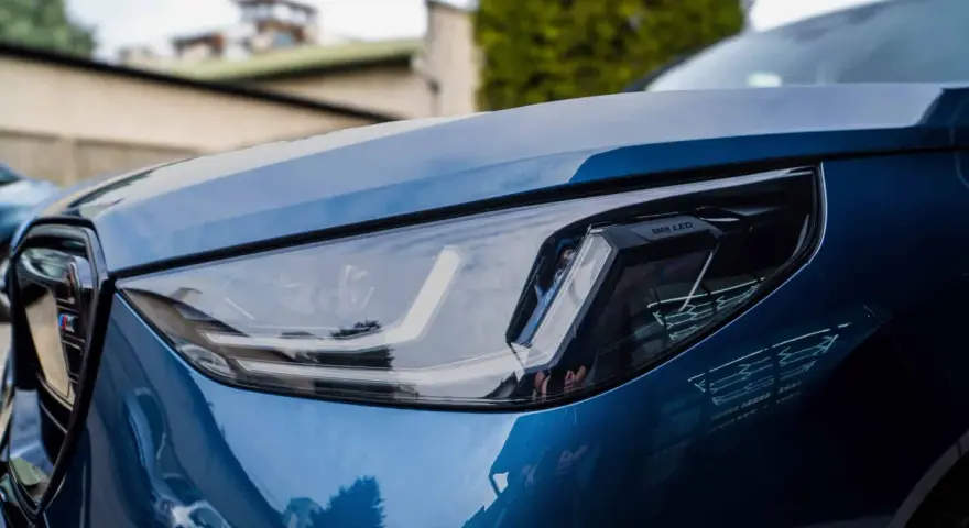Błyszczący, niebieski lakier BMW z reflektorem LED. To właśnie autodetailing co to znaczy, że samochód wygląda jak nowy.