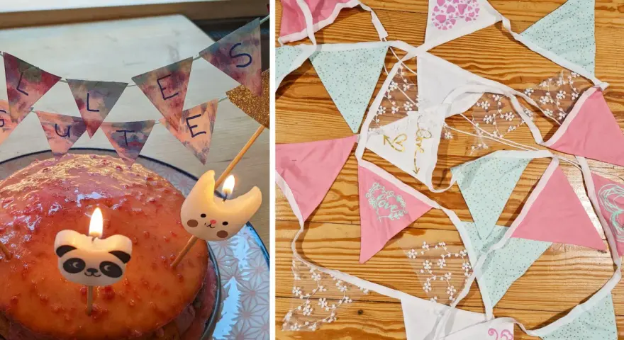 Geburtstagstorte mit Kerzen und einer selbstgemachten Wimpelkette. Daneben liegen weitere bunte Wimpelketten zum Basteln.
