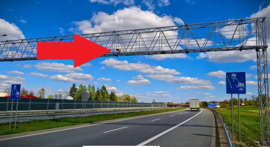 Czerwona strzałka wskazuje na bramownicę z kamerami odcinkowego pomiaru prędkości nad autostradą A4.