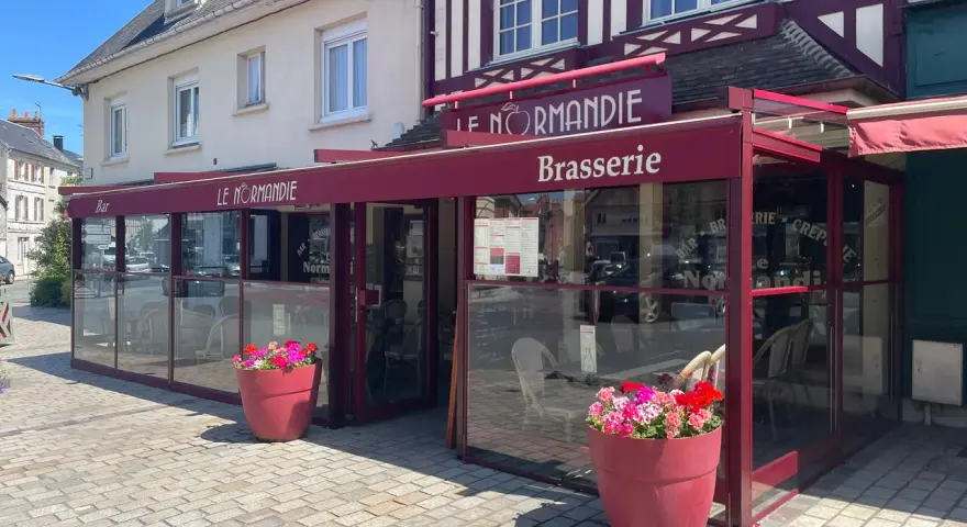 Brasserie Le Normandie, un lieu idéal pour déguster un bon pont l'évêque, fromage au goût unique. Fleurs colorées devant.
