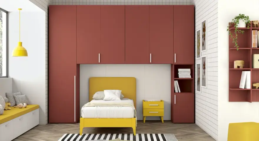Soluzione perfetta per organizzare armadio a ponte bambini: letto giallo, armadi rossi e tanto spazio per giocare.