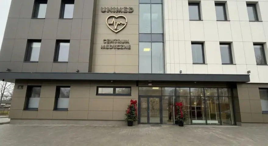 Nowoczesny budynek centrum medycznego Unimed z logo serca i pulsu.