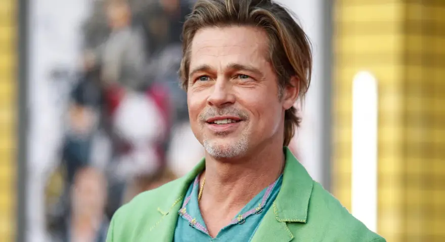 Brad Pitt, attore famoso, sorride con un completo verde acceso.