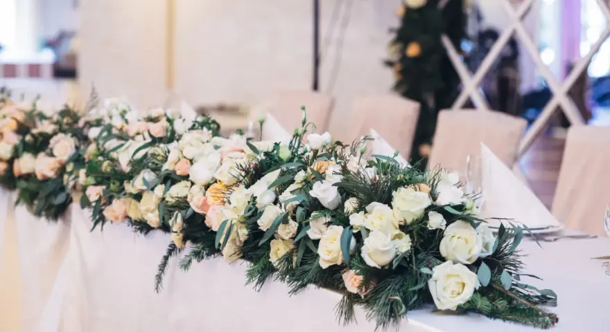 Eleganckie kwiaty na wesele zdobią stół, tworząc romantyczną atmosferę. Bukiet z róż i zieleni.