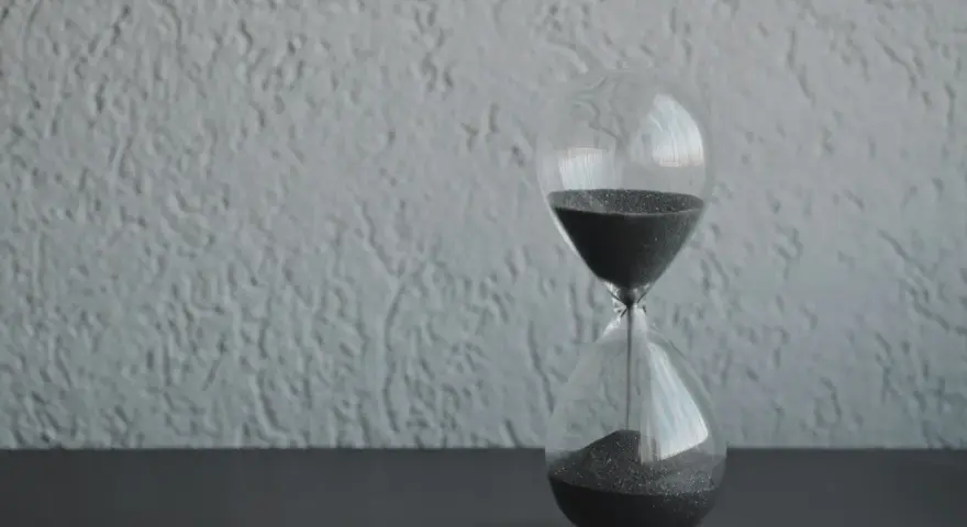 Clessidra con sabbia nera che scorre, simbolo del tempo che passa. Quanto tempo portare il lutto? Il tempo guarisce, ma il ricordo resta.