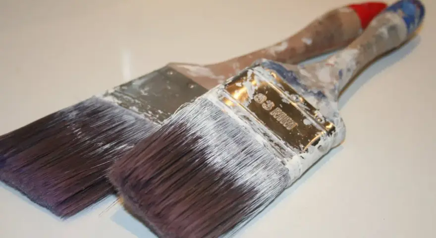 Deux pinceaux usagés, couverts de peinture blanche séchée. Que faire avec ce pinceau sec ?