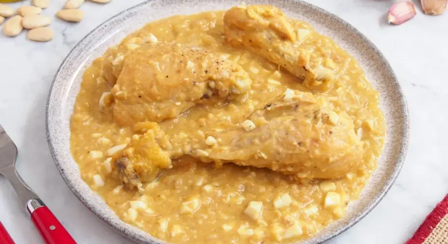 Pollo en pepitoria, un plato tradicional con trozos de pollo en una salsa cremosa de almendras y huevo duro.