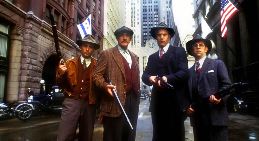 Quatre hommes en costume et chapeau, armés, se tiennent dans une rue de Chicago. Une scène tirée de "Les Incorruptibles, histoire vraie".