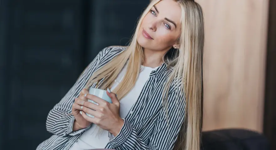 Blondynka z kubkiem w dłoniach, zamyślona, chce być sama.