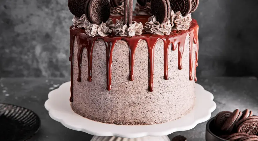 Ein köstlicher Oreo Kuchen mit Schokoladenglasur und vielen Oreos obendrauf.