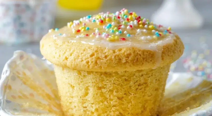 Ein Fanta-Muffin mit Zuckerguss und bunten Streuseln, bereit zum Genießen.