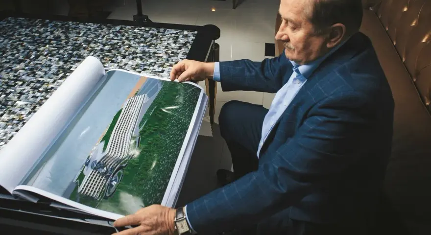 Henryk Gołębiewski, właściciel hoteli, ogląda projekt nowoczesnego hotelu zlokalizowanego nad wodą.