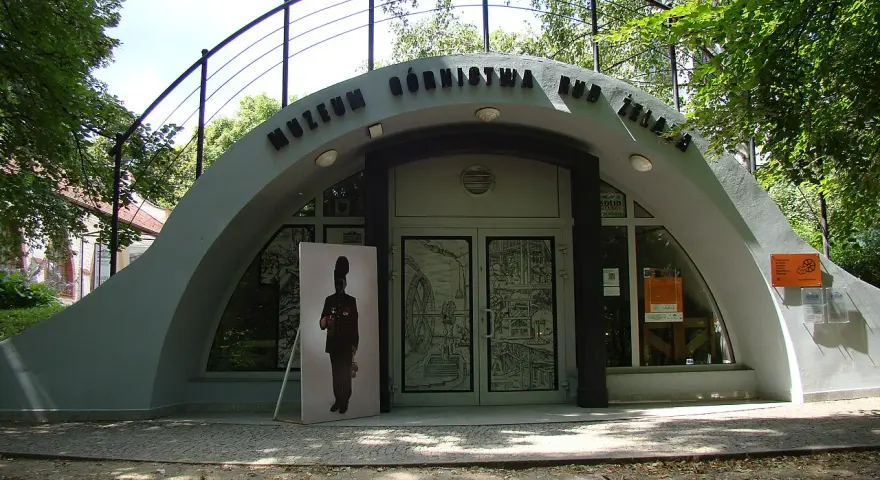 Wejście do Muzeum Górnictwa Rud Żelaza. Przed budynkiem stoi wielkoformatowy portret górnika.