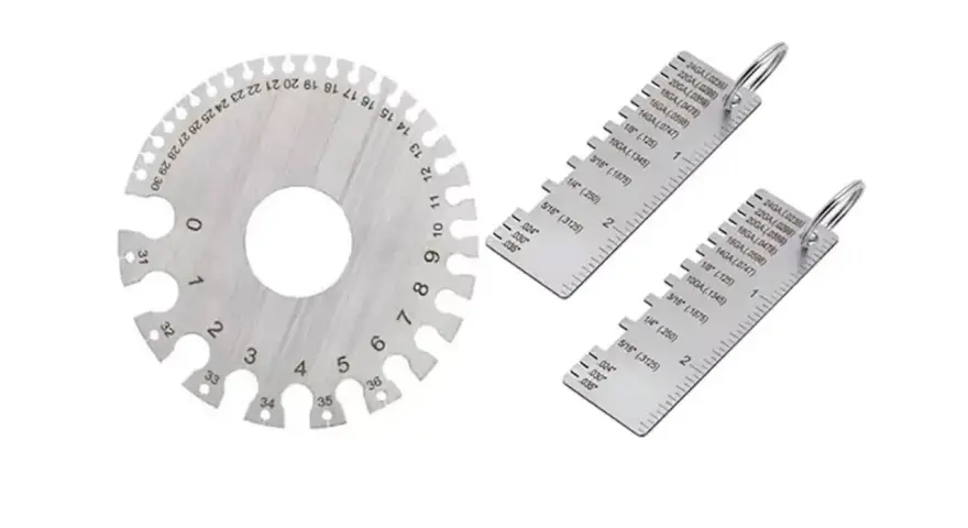 Strumenti di misurazione metallici, tra cui un disco graduato e due righelli, utili per determinare la portata di un calibro.