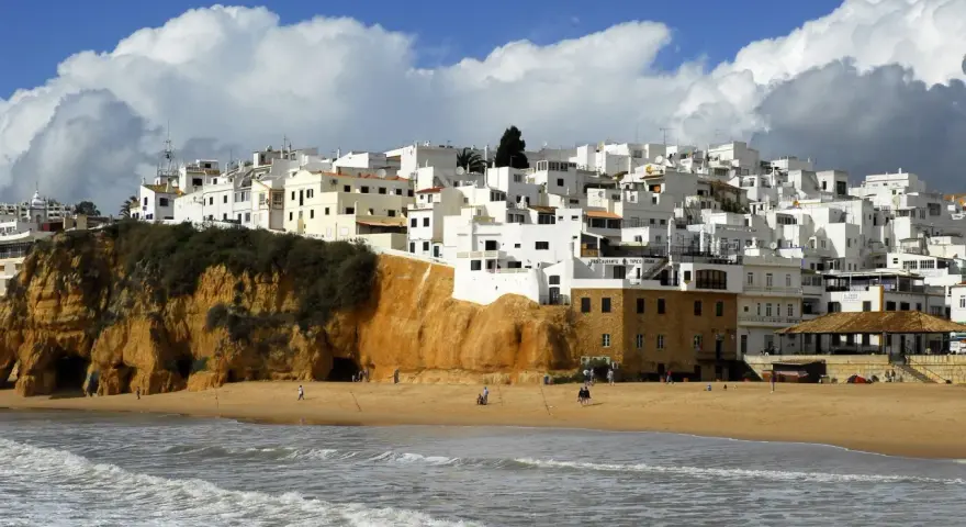Białe domy na klifie, plaża i morze. Portugalia pogoda roczna, idealna na spacer.