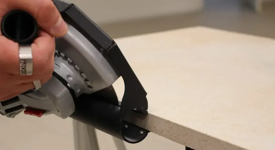 Hand mit Ring hält Winkelschleifer zum präzisen Fliesenschneiden.