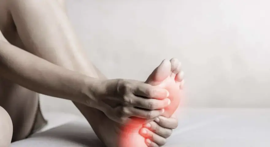 A person holds their foot, with red highlights indicating discomfort. This image evokes the feeling of needing natural foot detox.
