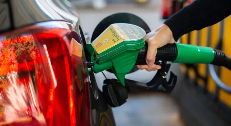 Tankstelle: Eine Hand betankt ein Auto mit dem grünen Zapfhahn. So behältst du im Blick, wie viel verbraucht dein Auto.