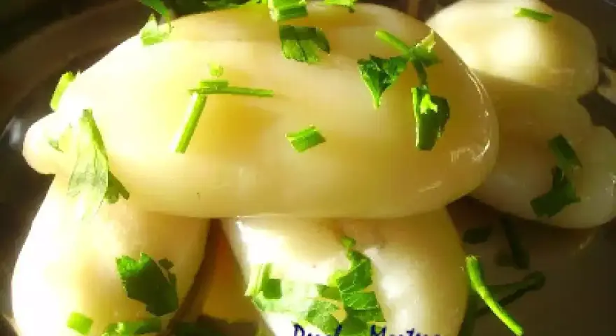 Deliciosos huevos de choco cocidos, servidos en un plato y adornados con perejil fresco picado.